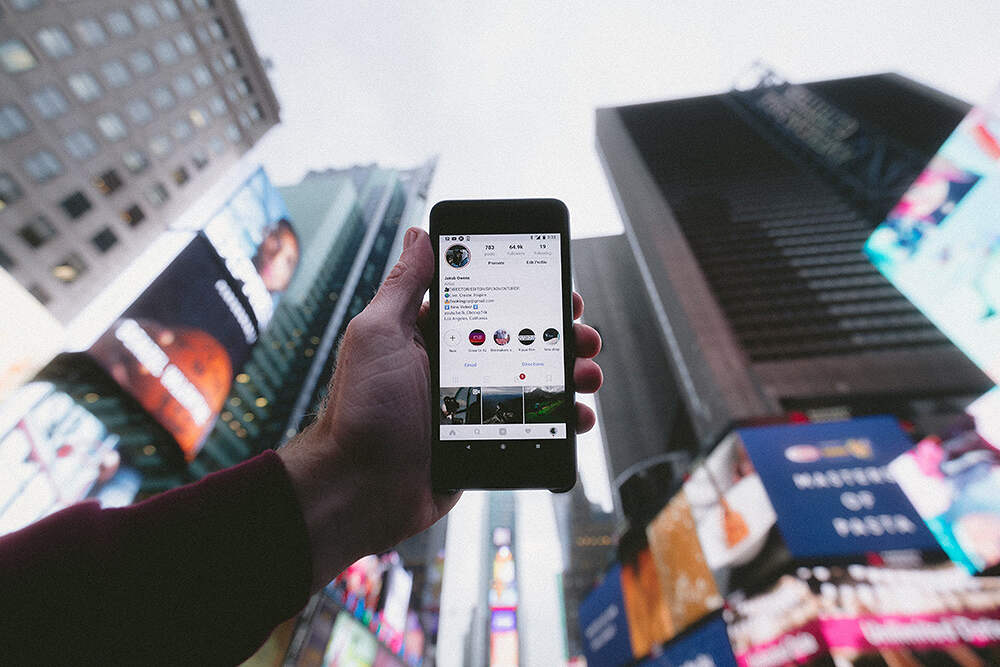person holding cellphone outside in a city